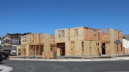 Framed new-construction home under a clear sky