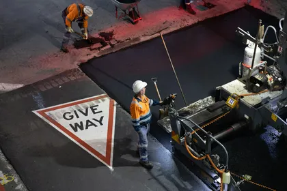 Asphalt paving rollers compacting a fresh road surface